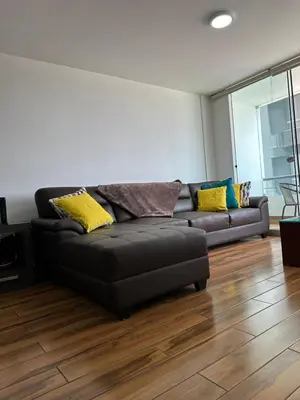 a black leather couch in a living room with wood floors at El Derby 511 Apart 2 Dorm con Aire Acondicionado in Lima