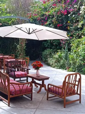 a group of tables and chairs with an umbrella at Casa Munayki in Ayacucho