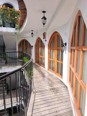 a corridor of a building with wooden doors and windows at Casa Munayki in Ayacucho