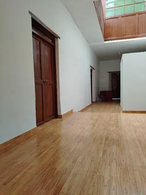 an empty room with a wooden floor and a refrigerator at Hotel House in Perú 2 in Urubamba