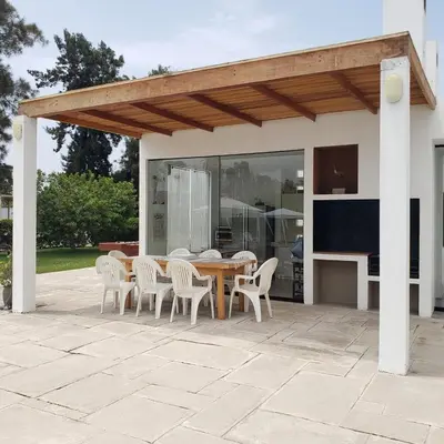 a wooden table and chairs on a patio at Casa de Campo con lago en Mala in Mala