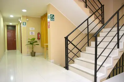 a hallway of a hospital with stairs and a plant at hostal kiara in Huairona
