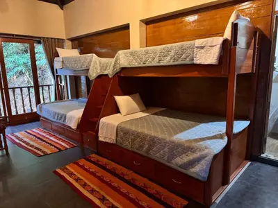 two bunk beds in a room with a window at Waranway Lodge Huayopata in Quillabamba