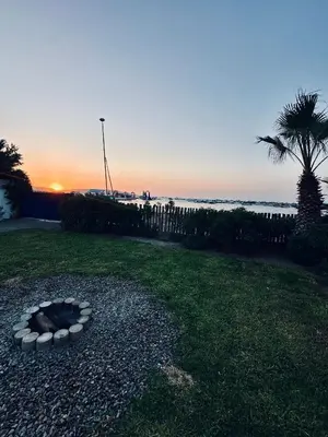 a fire pit in the grass next to the beach at Casa Paraquitas 