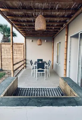 a patio with a table and chairs under a pergola at Casa Paraquitas 