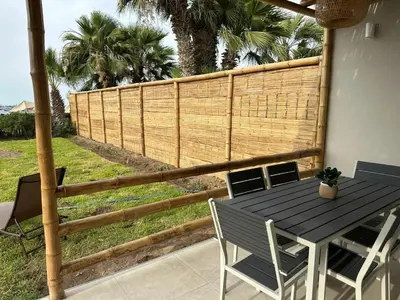 a table and chairs on a patio with a fence at Casa Paraquitas 