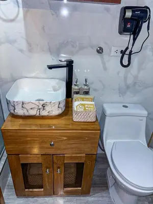 a bathroom with a white toilet and a sink at Rumi Wasi Inn Ollantaytambo in Ollantaytambo