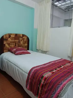 a bedroom with a bed with a blanket on it at Añay Ayllu in Cusco