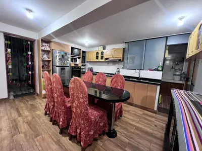 a kitchen with a dining table and red chairs at Adela's Home in Cusco
