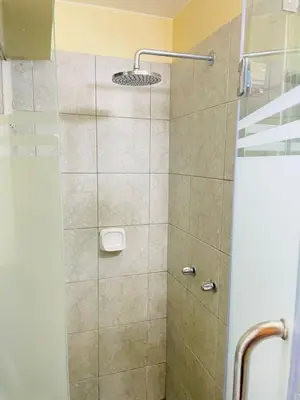 a bathroom with a shower with a glass door at El encanto de viajar in Lima