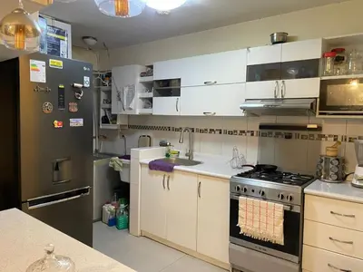 a kitchen with white cabinets and a stove at El encanto de viajar in Lima