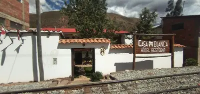 a small white building with a sign in front of it at Hospedaje CASABLANCA URUBAMBA in Urubamba