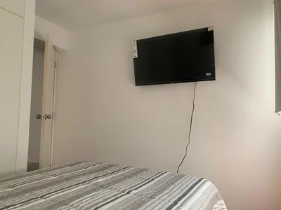 a flat screen tv hanging on a white wall at Departamento en Miraflores in Lima