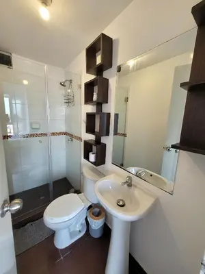 a white bathroom with a toilet and a sink at Modern and comfortable apartment nearby Aairport in Lima