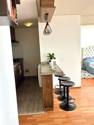 a kitchen with a counter and stools in a room at Modern and comfortable apartment nearby Aairport in Lima