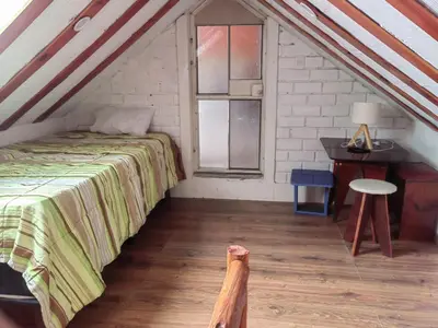 a bedroom with a bed and a desk in a attic at Residencial Misky Dreams in Huánuco