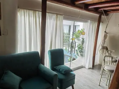 a living room with a couch and a large window at Residencial Misky Dreams in Huánuco