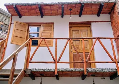 a balcony of a house with wooden doors at Casa Qantu Huaytará in Huaytará