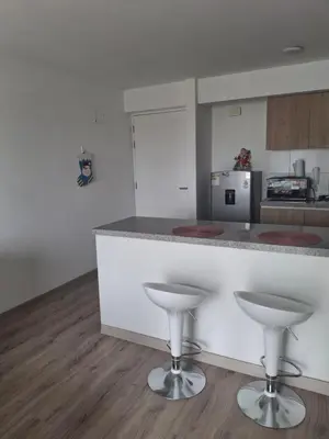 a kitchen with a counter and two stools at Se alquila habitación con cama King y baño privado in Lima