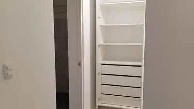 a white closet with empty shelves in a room at Se alquila habitación con cama King y baño privado in Lima