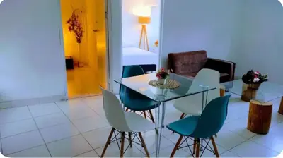 a dining room with a glass table and blue chairs at Apart Hotel Nazarenas in Ayacucho