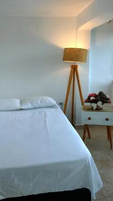 a bedroom with a bed and a table with a lamp at Apart Hotel Nazarenas in Ayacucho