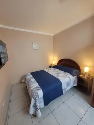 a bedroom with a bed with a blue and white blanket at AlojamientoMarín in Lima