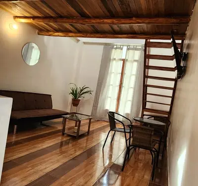 a living room with a staircase and a table and chairs at Loft Casa Yucay in Yucay