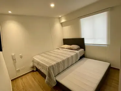 a small bedroom with a bed and a window at Departamento in Magdalena del Mar in Lima