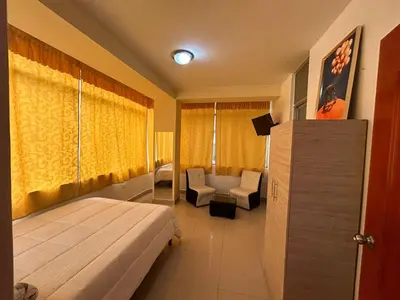 a hotel room with a bed and a couch at Hotel Paraiso L & M in Huánuco