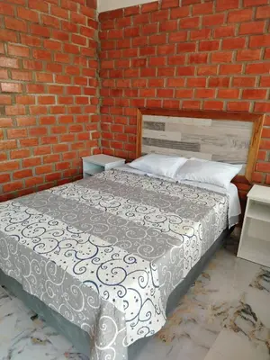 a bedroom with a bed in a brick wall at Oliver's Garden Country Hotel in Chincha
