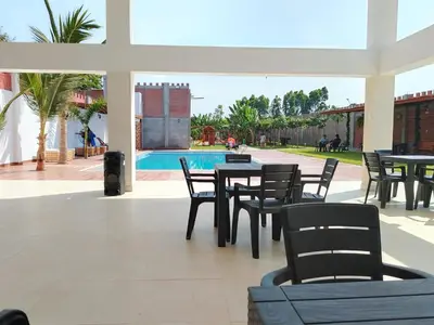 a patio with tables and chairs and a pool at Oliver's Garden Country Hotel in Chincha