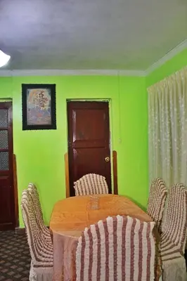 a dining room with green walls and a table and chairs at Casita San Pedro in Cusco