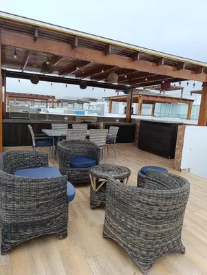 a patio with wicker chairs and tables on a boat at casa en playa de condominio mikonos in Asia