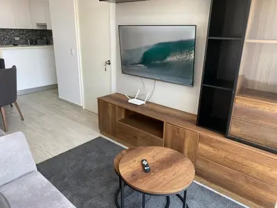a living room with a television and a table at Monumental BR1 in Lima