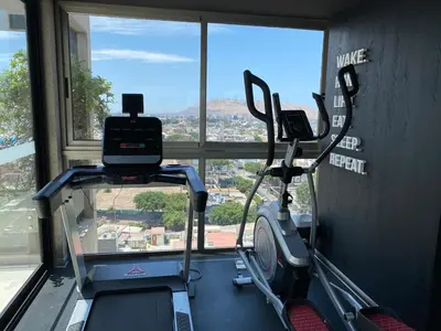 a gym with a treadmill in a room with a window at Monumental BR1 in Lima