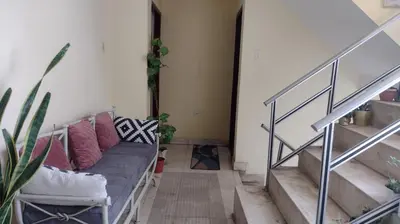 a living room with a couch and stairs at Apart Hotel Valdelomar in Ayacucho