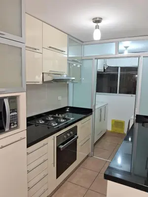 a kitchen with white cabinets and a stove top oven at CasaBlanca2 in Lima