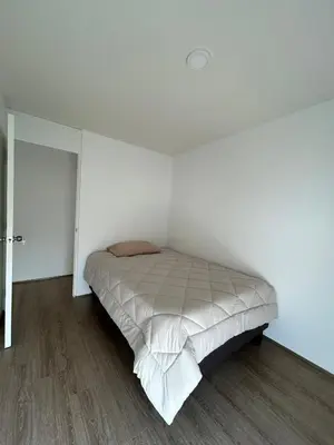 a white bedroom with a bed in the corner at Departamento en San Bartolo in San Bartolo