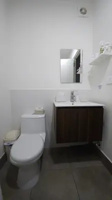 a white bathroom with a toilet and a sink at Departamento con Increíble ubicación en San Miguel in Lima