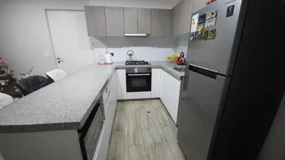 a kitchen with a refrigerator and a wooden floor at Departamento con Increíble ubicación en San Miguel in Lima