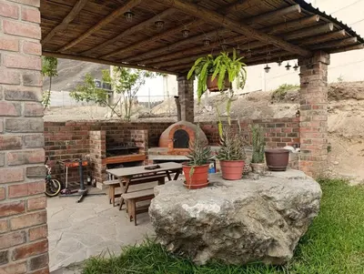 a patio with a table and potted plants on a rock at Country house in Pachacamac in Lima