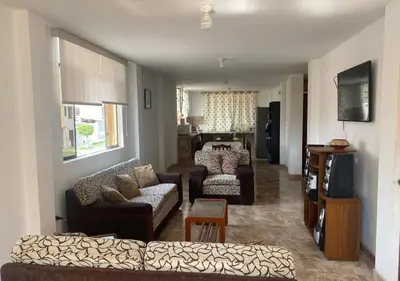 a living room with two couches and a tv at Departamento cerca a Cerro Azul in Hualcará