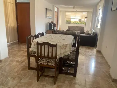 a living room with a table and chairs and a couch at Departamento cerca a Cerro Azul in Hualcará