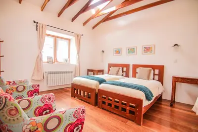 a bedroom with two beds and a couch at QOSQO BELVEDERE, apartamento en Cuesta San Blas in Cusco
