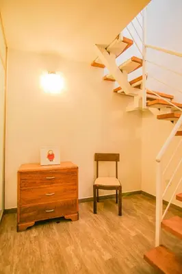 a room with a table and a chair and a staircase at QOSQO BELVEDERE, apartamento en Cuesta San Blas in Cusco