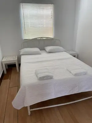 a large white bed with two pillows on it at Lindo departamento muy cerca a la playa in Punta Negra