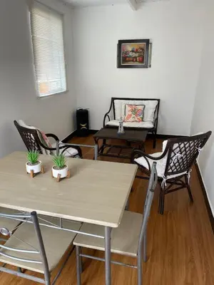 a living room with a table and chairs and a couch at Lindo departamento muy cerca a la playa in Punta Negra