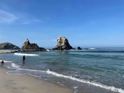 two people standing in the water at the beach at Mini Dpto frente al mar playa Pta N in Punta Negra
