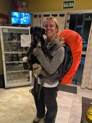 a woman is holding a black and white dog at Atenas Backpacker Hospedaje in Paracas